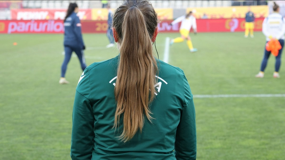 A woman watches a soccer game